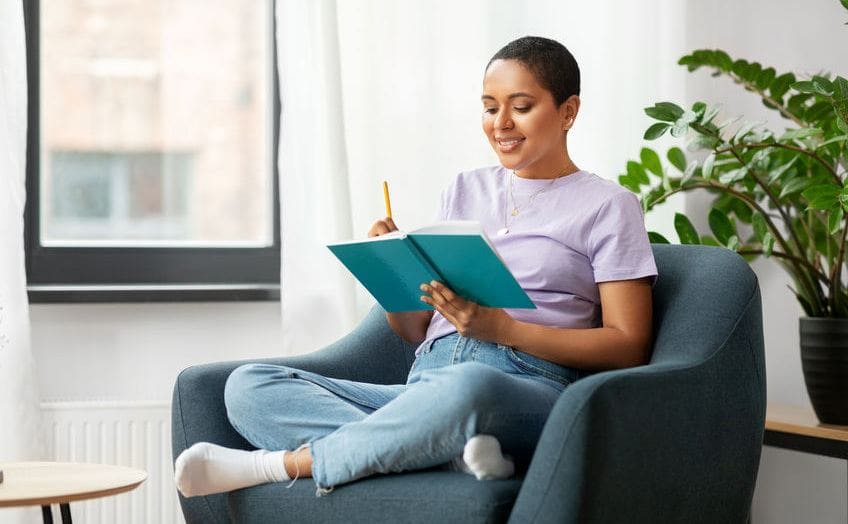 African American woman writing in a notebook