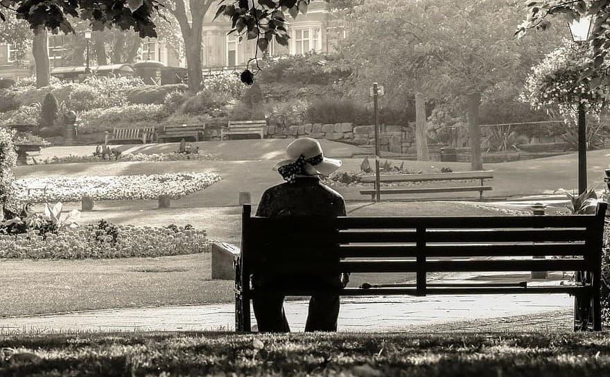 A woman sitting alone on a park bench