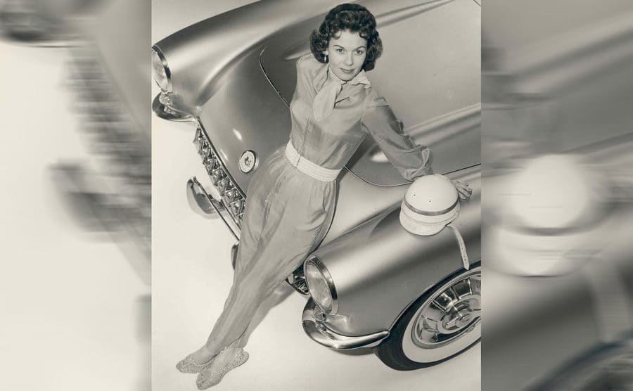 Betty Skelton posing on the front of a Corvette