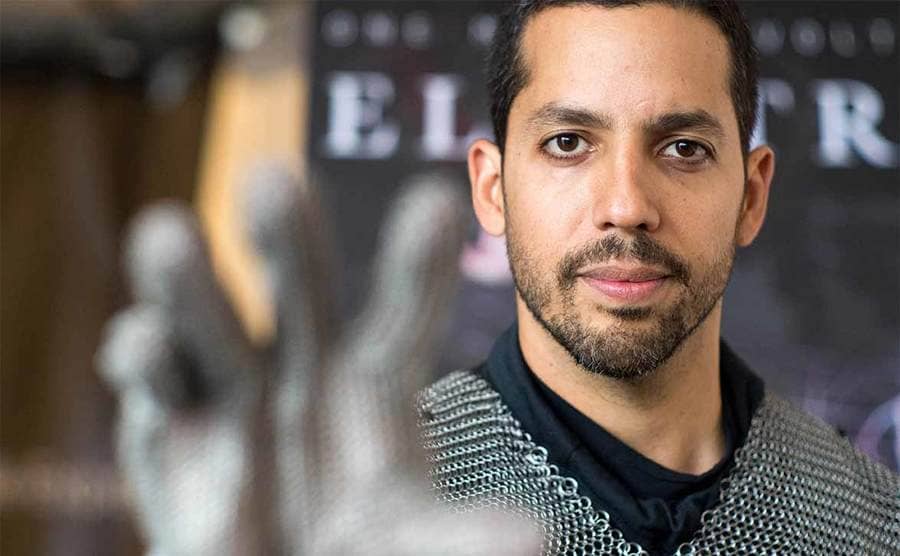 David Blaine wearing all metal with his hand extended