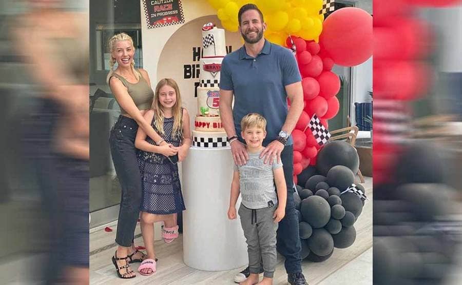 Heather and Tarek with his children standing in front of a birthday cake for his son, whose birthday is a day after Tareks