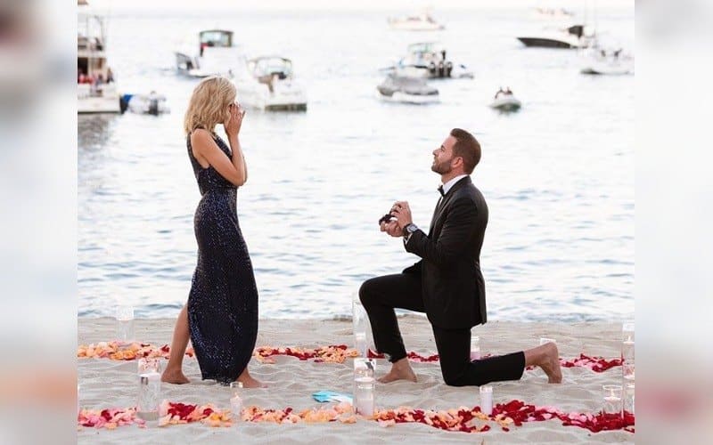 Tarek down on one knee, proposing to Heather on the beach