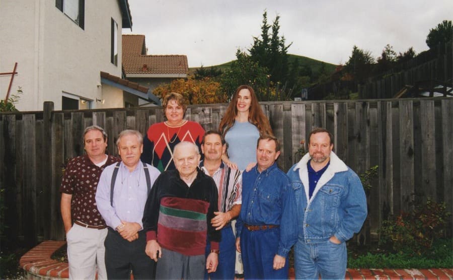 Alice and her sister and brothers posing with their dad standing in front of them