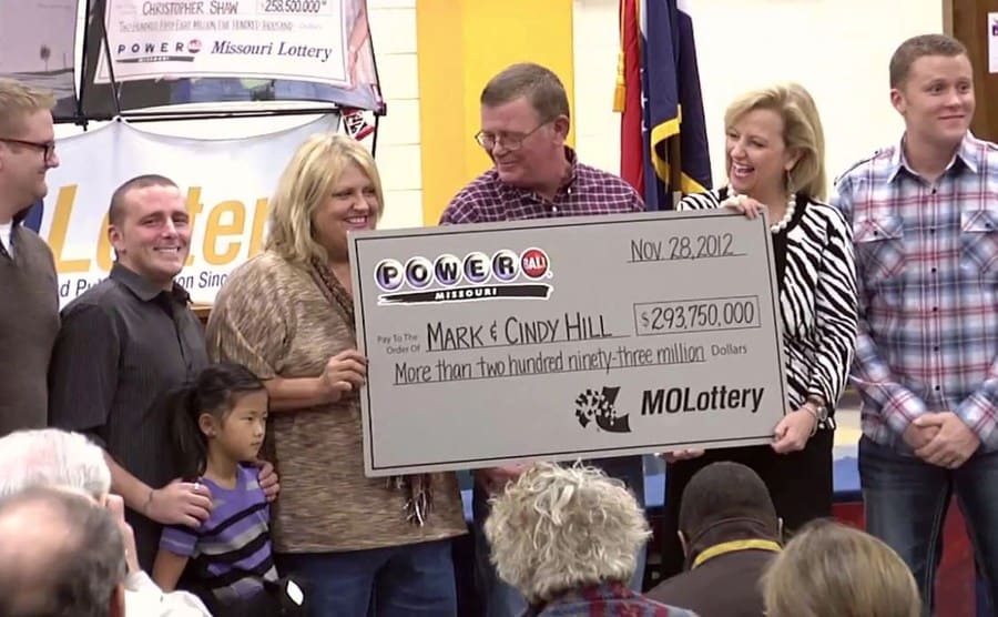Cindy and Mark Hill holding their check with their family around them