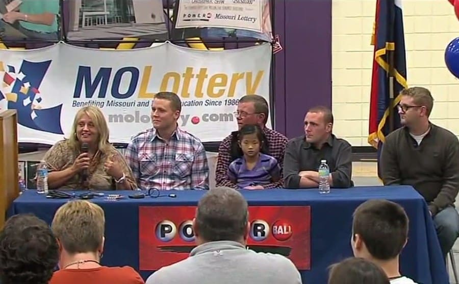 Cindy and Mark Hill holding their check with their family around them