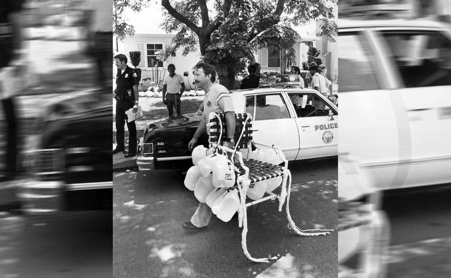 Larry carrying his chair, passed a police car