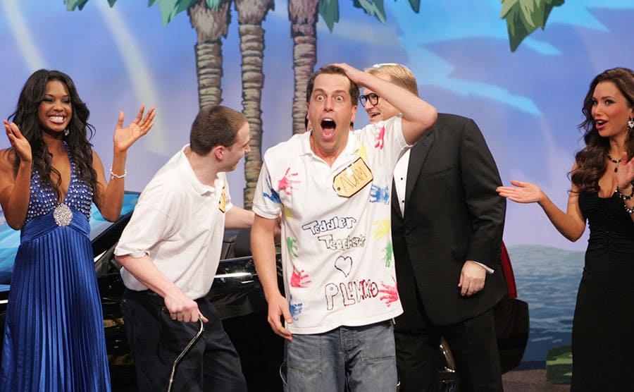 A man named Adam looking excited while him and others stand around a nice car on the Price is Right