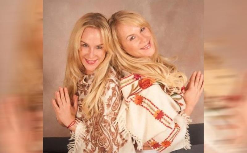 The twins posing back to back with their palms together