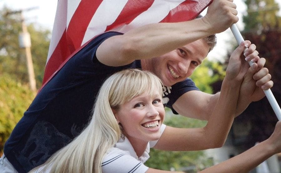 Sherri Papini and her husband Keith holding together a flag and smiling
