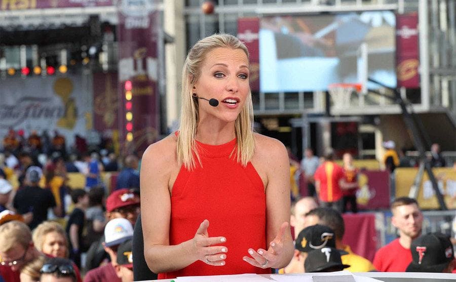 Lindsay Czarniac broadcasting in a red dress