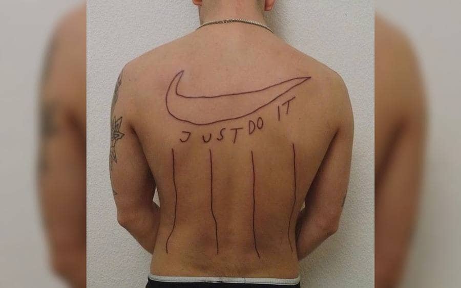 A tattoo on a guy's back with Nike logo
