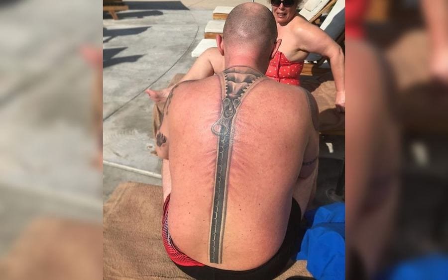 A tattoo of a zipper on a guy's back