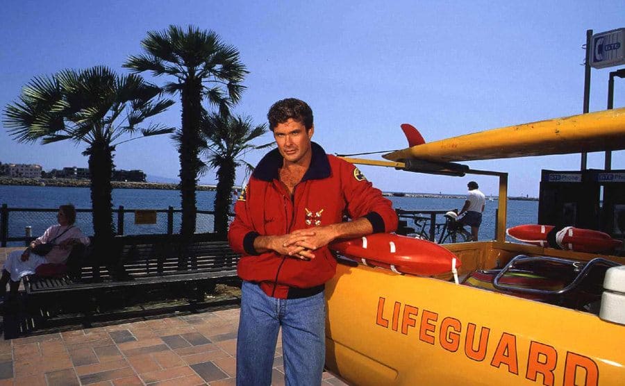 David Hasselhoff standing by a yellow truck with a softboard attached