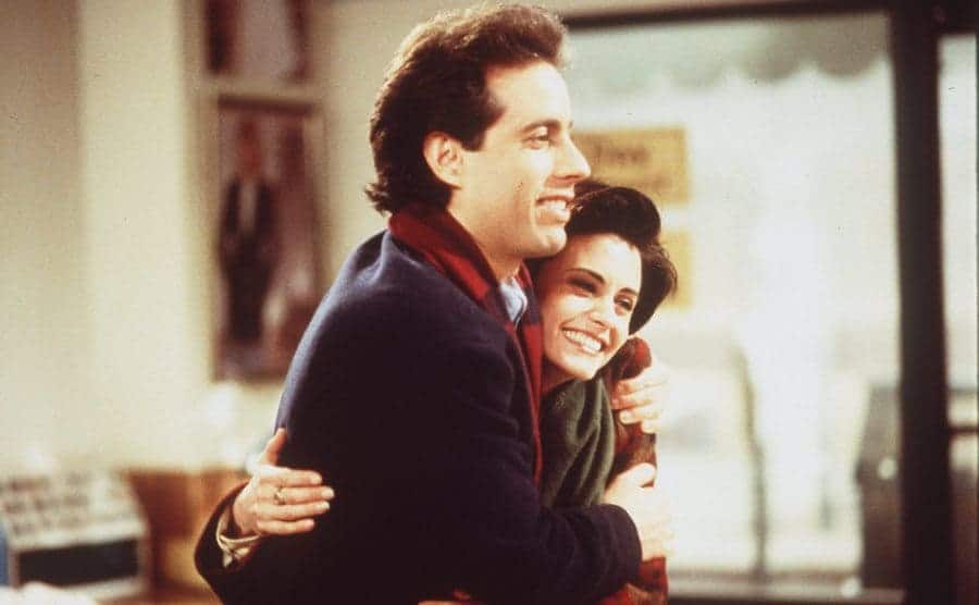 Jerry Seinfeld hugging Courteney Cox in an episode of Seinfeld