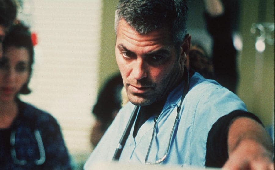 George Clooney in scrubs looking serious in a scene from ER