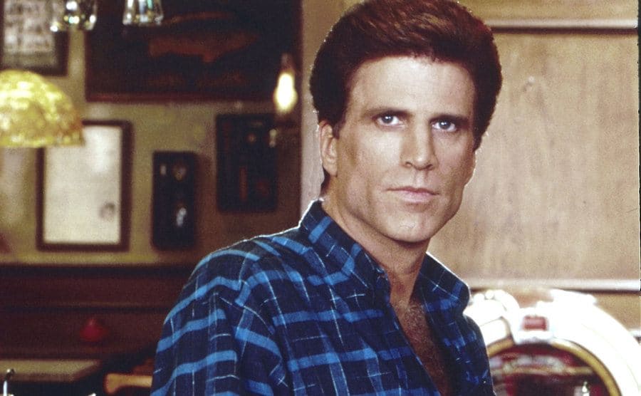 Ted Danson holding a soda tap behind a bar