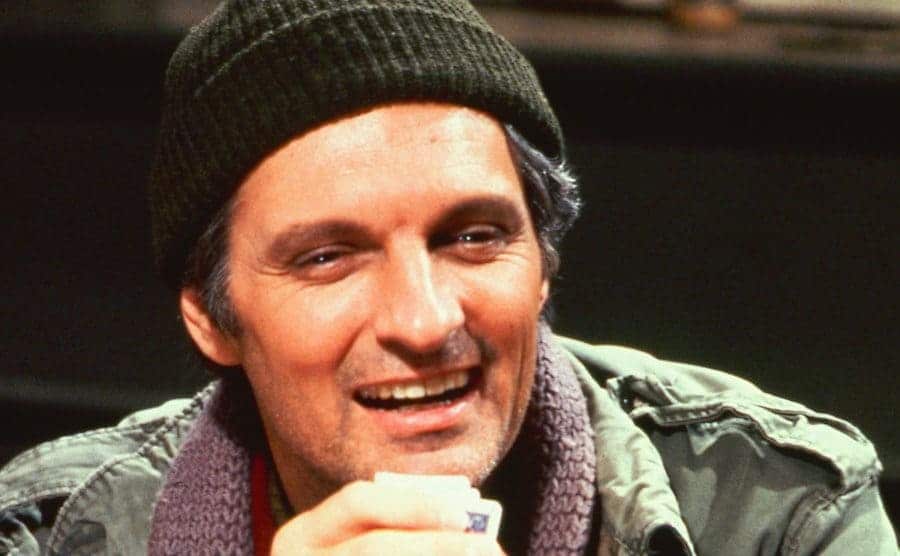 Alan Alda in M*A*S*H holding a deck of cards