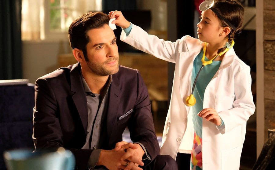 Tom Ellis playing doctor with Scarlett Estevez in a scene from Lucifer