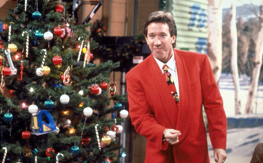 Tim Allen standing by a Christmas Tree at his garage