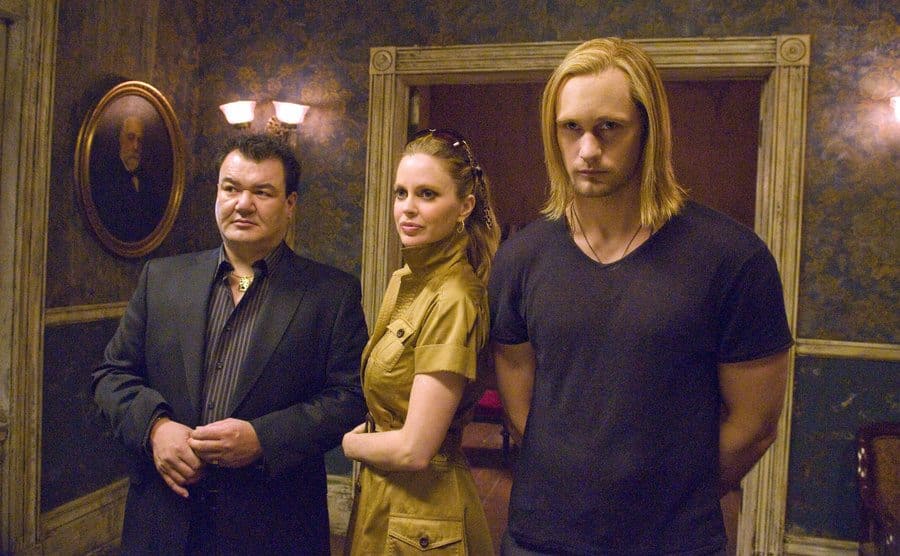 Alexander Skarsgard, Kristin Bauer van Straten, and Patrick Gallagher posing next to each other in a creepy hallway