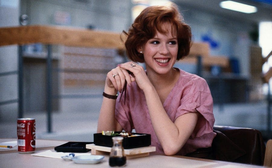 Molly Ringwald sitting at the table with her lunch and a can of Coca Cola