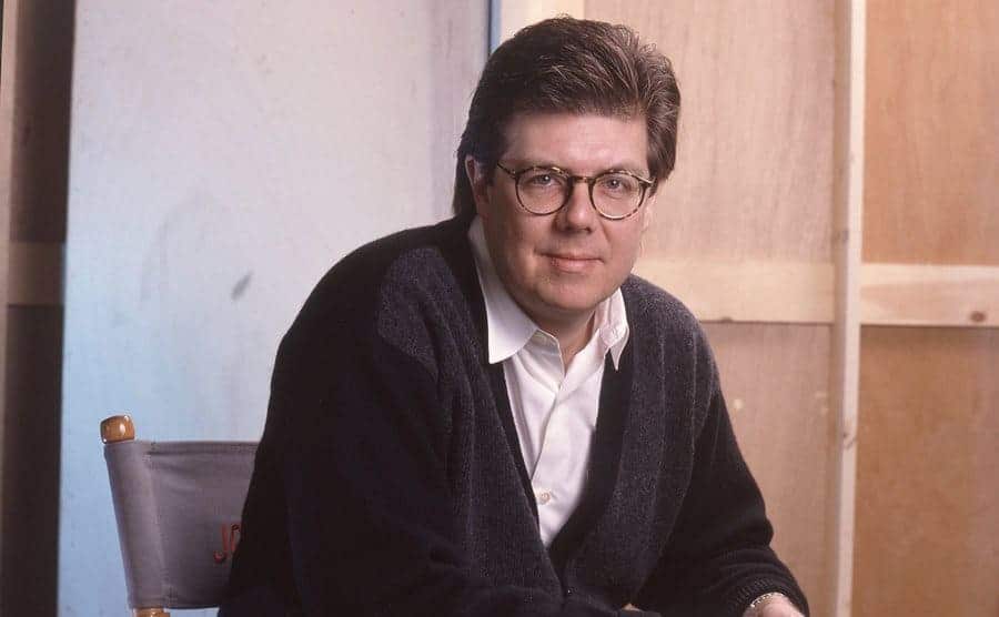 John Hughes sitting in the director's chair circa 1990