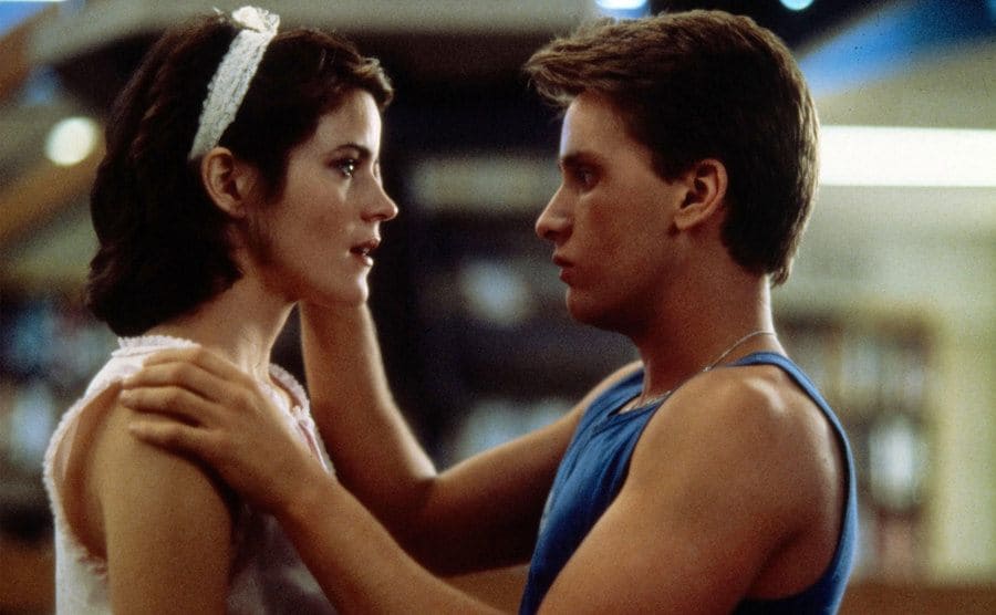 Emilio Estevez brushing Ally Sheedy’s hair behind her ear in a scene from The Breakfast Club