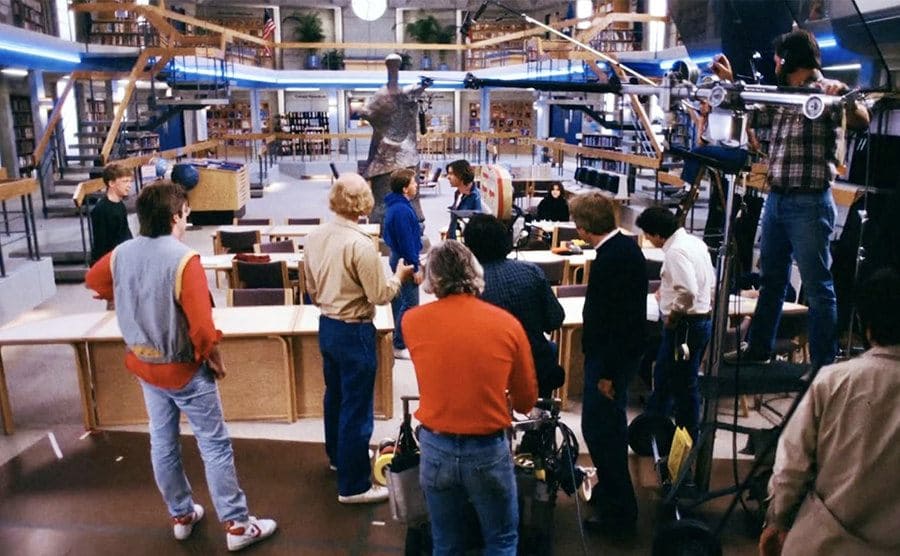 A behind the scenes photograph of the school library with cameras and crew all around