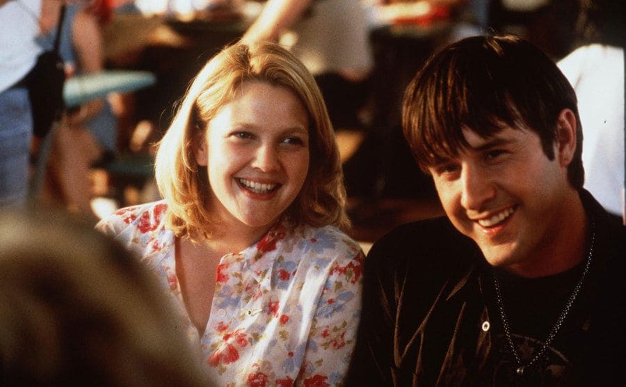 Drew Barrymore and David Arquette sitting in the cafeteria