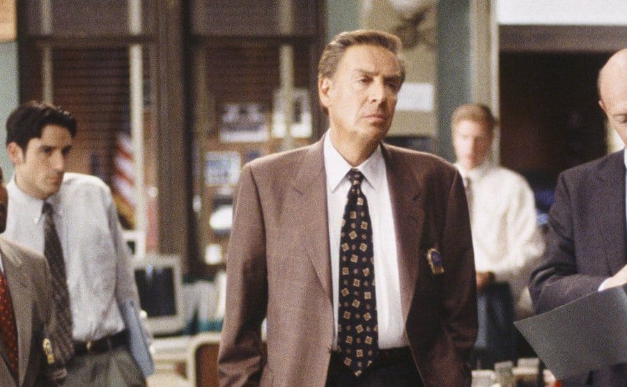 Jerry Orbach as Lennie Biscoe standing with detectives around him in a scene from Law and Order