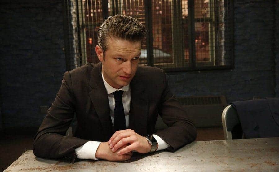 Peter Scanavino as Sonny Carisi sitting in the interrogation room