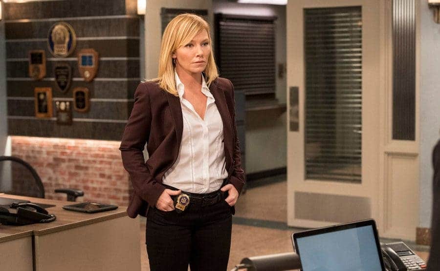 Kelli Giddish as Amanda Rollins standing in the precinct