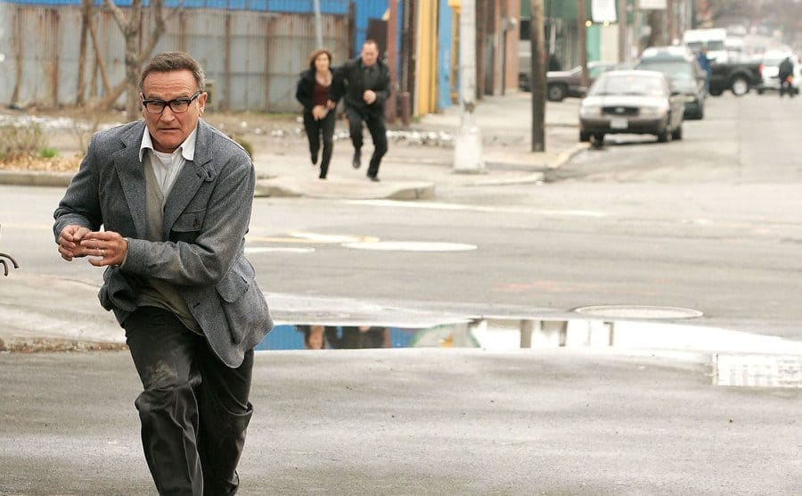 Mariska Hargitay and Christopher Meloni running after Robin Williams in a scene from Law and Order