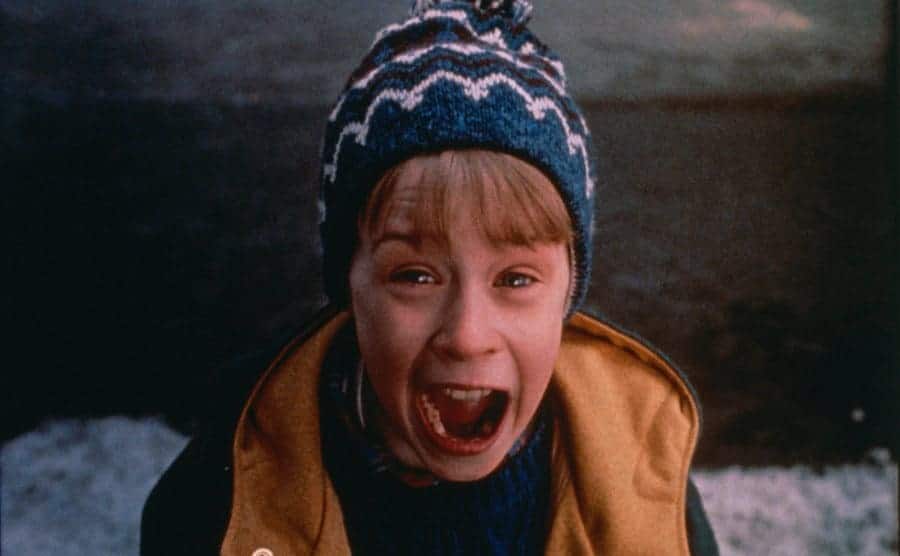 Macaulay Culkin in winter clothing screaming and looking upwards