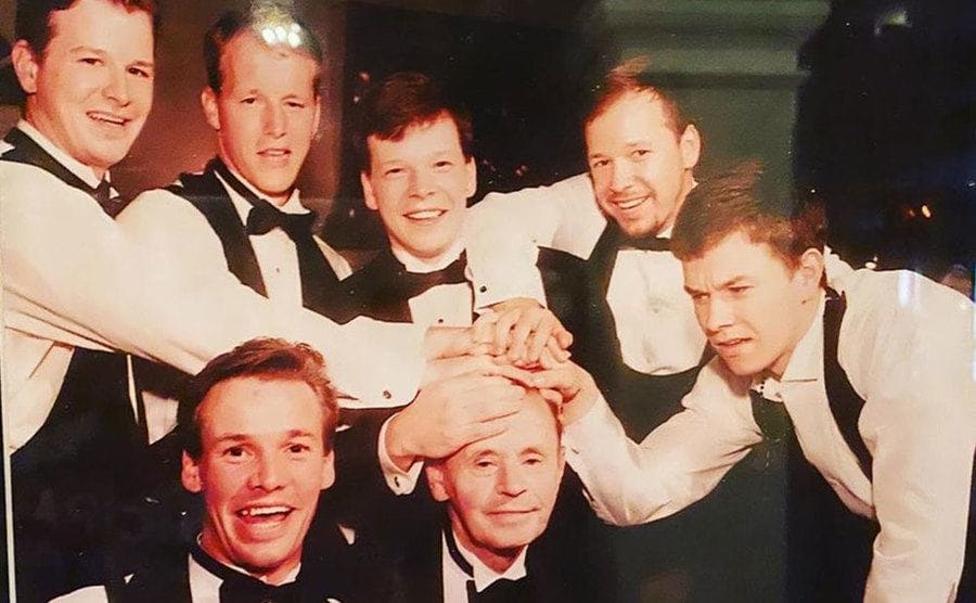 Mark and his brothers with their hands on their fathers head
