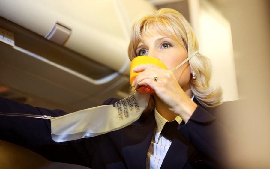 Flight attendant with an oxygen mask