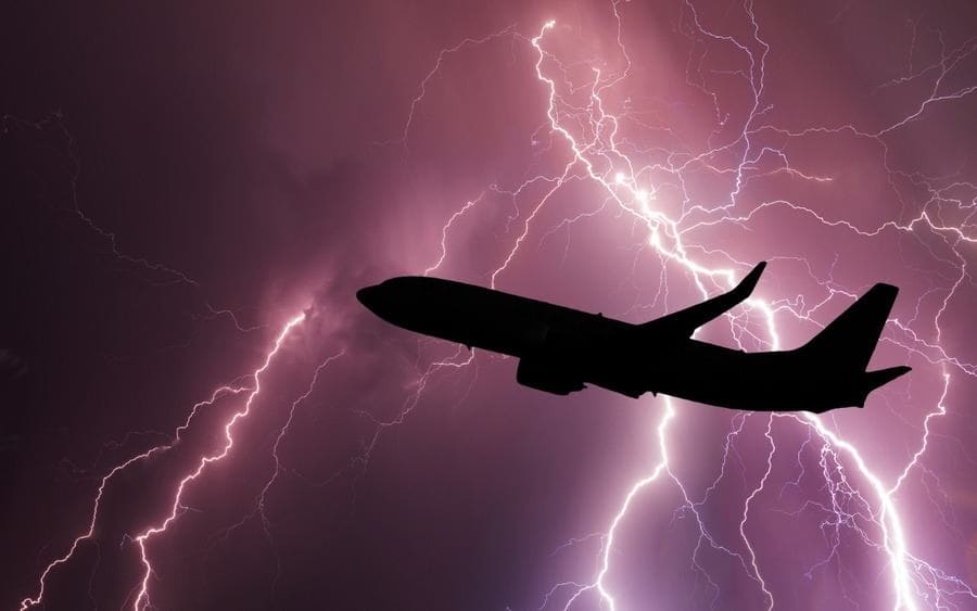Airplane silhouette on the background of a stormy sky with lightning