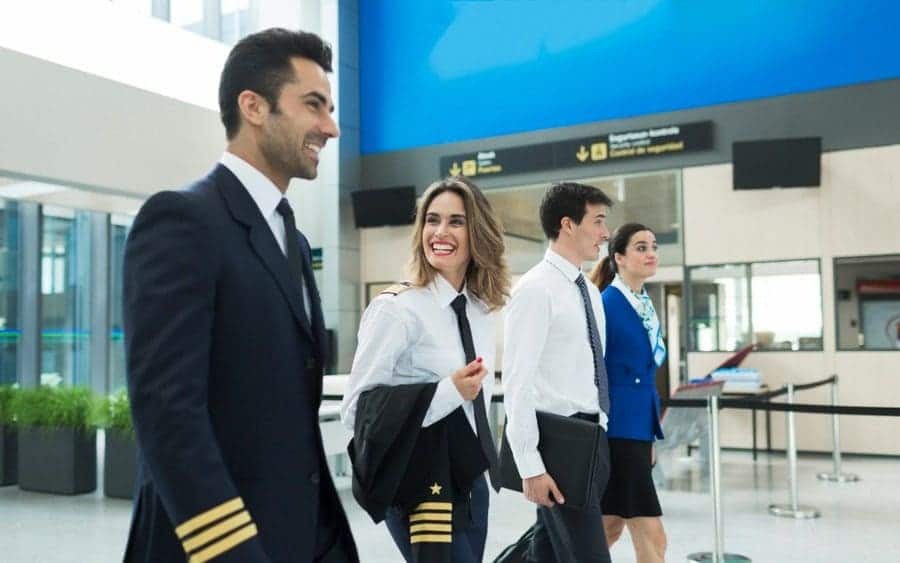 Plane crew walking in an airport terminal near airline office