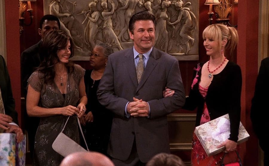 Lisa Kudrow being escorted into a party by Alec Baldwin while Courteney Cox and Matthew Perry 
