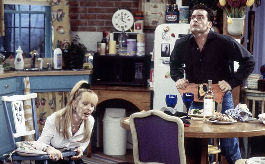 Lisa Kudrow and Charlie Sheen with white paste dotted all over them looking like they are in pain 