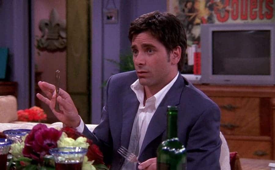 John Stamos looking a little uncomfortable while eating dinner at Monica and Chandler’s apartment 