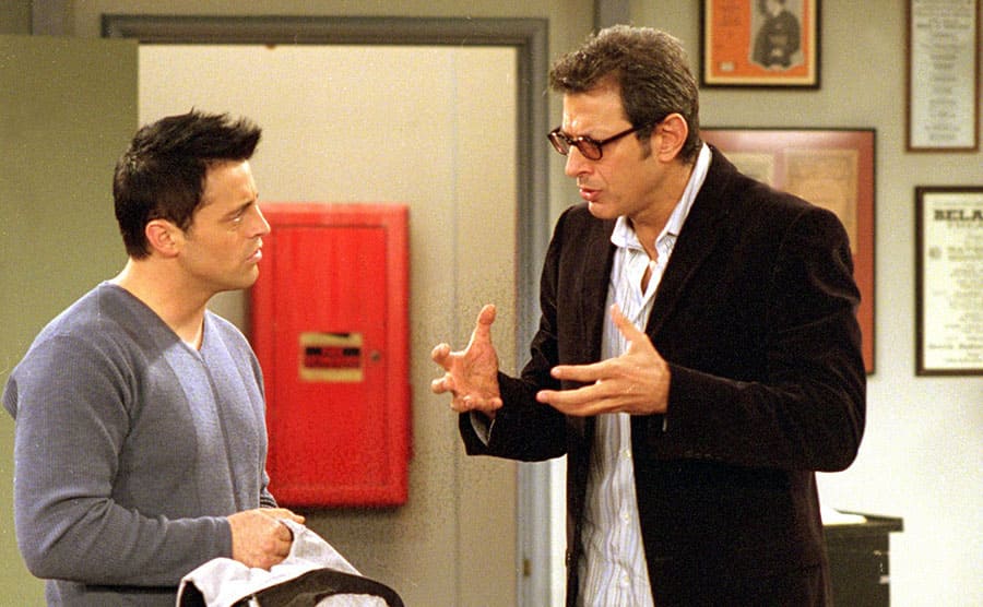 Matt LeBlanc and Jeff Goldblum standing in a room talking 