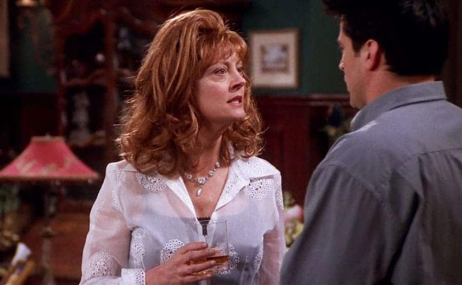Susan Sarandon holding a drink speaking to Matt LeBlanc in a scene from Friends