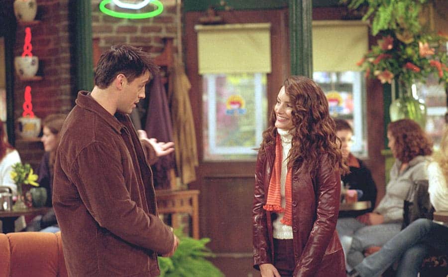 Matt Leblanc and Kristin Davis standing together in the coffee shop in a scene from Friends 