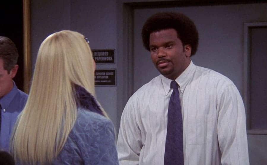 Craig Robinson talking to Lisa Kudrow in a scene from Friends 