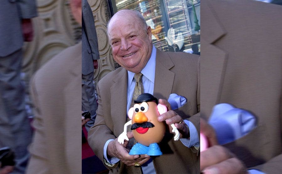 Don Rickles holding a Mr Potato Head doll on the red carpet