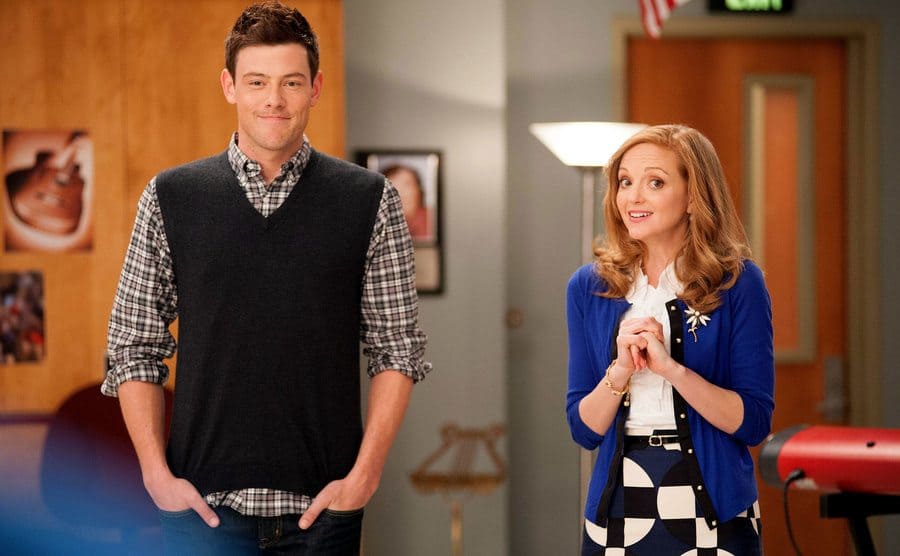 Cory Monteith with Jayma Mays standing in the band room in Glee