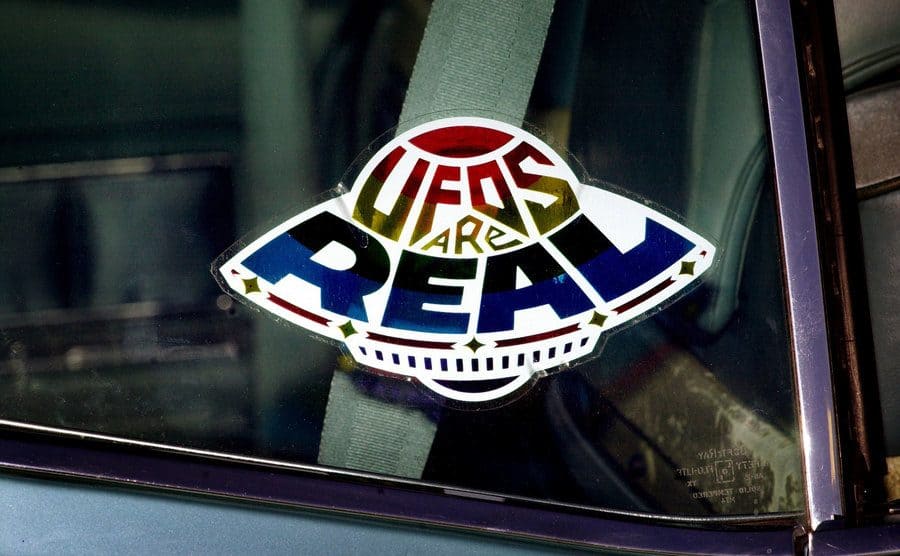 A sticker declares the existence of flying saucers from the window of a car parked on property near Jamul, CA, October 15, 2000.