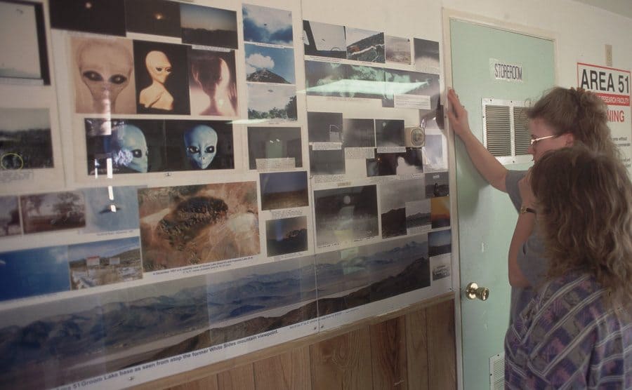 Visitors looking at different pictures of extraterrestrials at Little A'le' Inn, space alien-themed inn.