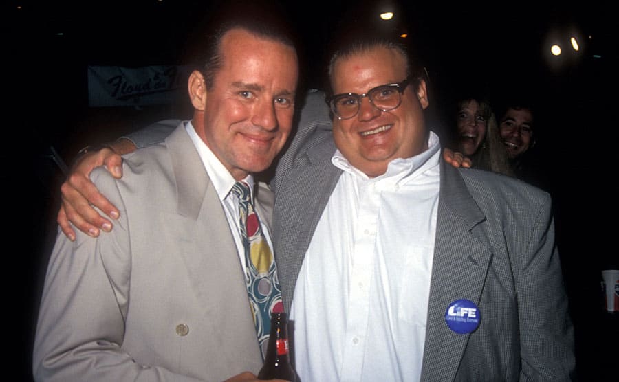 Phil Hartman and Chris Farley posing together at an SNL party